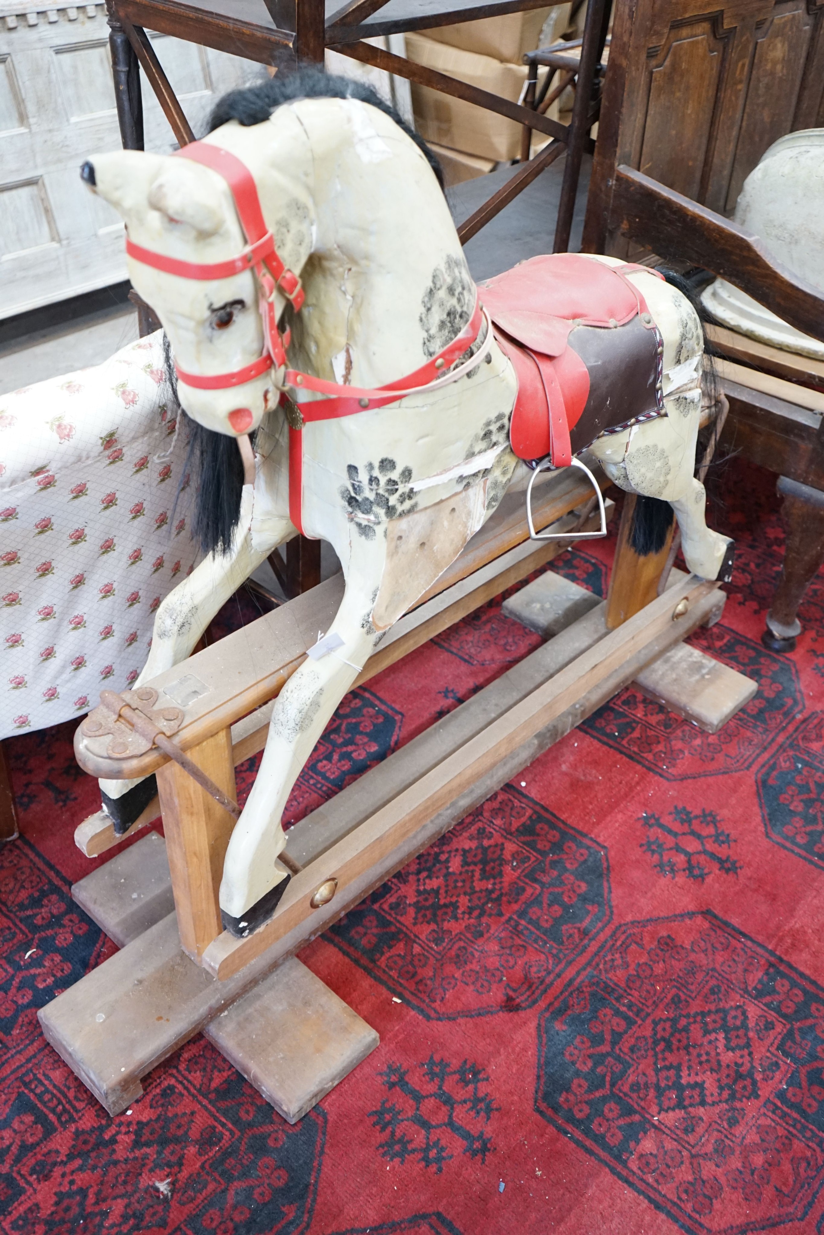 An Ayres type dappled rocking horse on pine safety frame, length 135cm